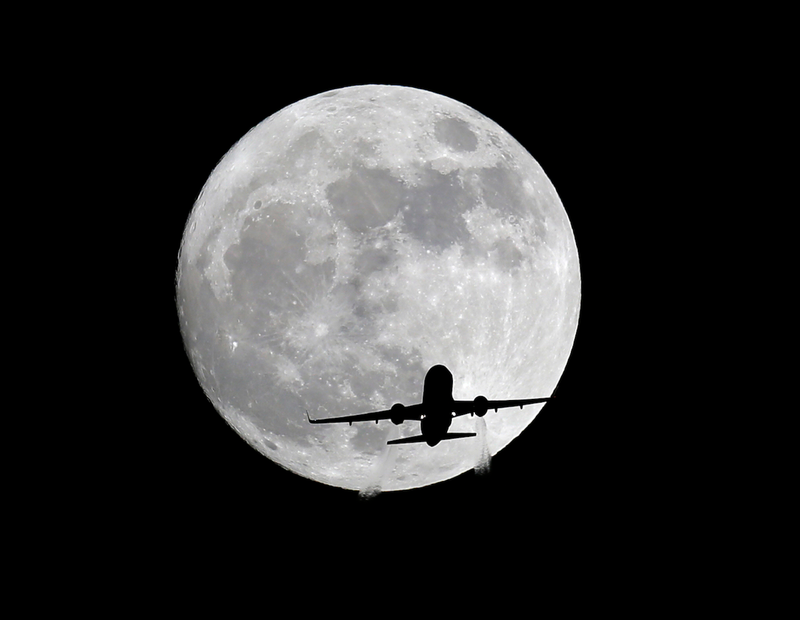 Un avión pasa por delante de la superluna en Whittier (California). Imagen: Nick Ut /AP